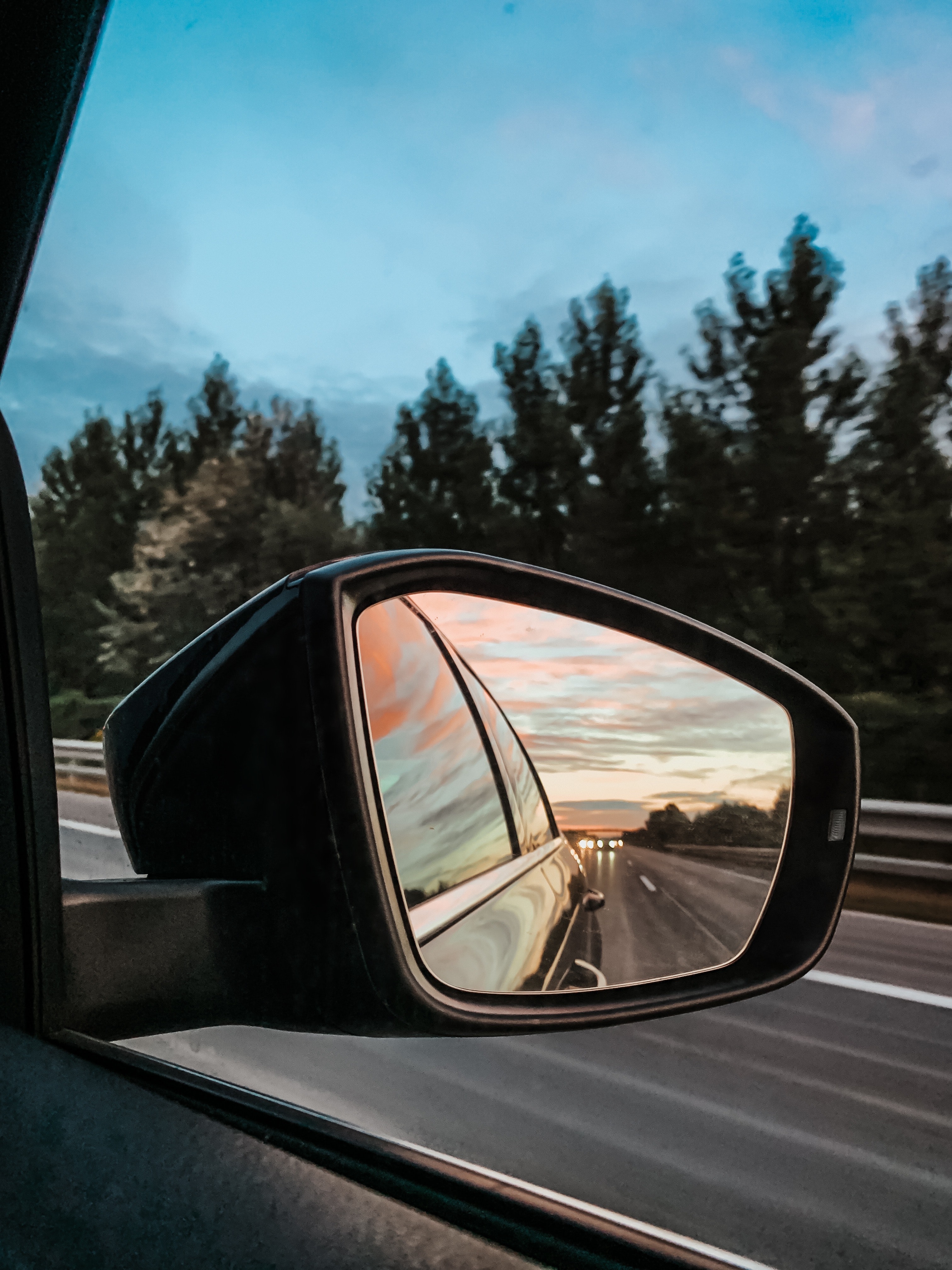 Photo of sky in side rearview mirror of moving vehicle